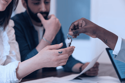 Agent handing over house keys to a buyer
